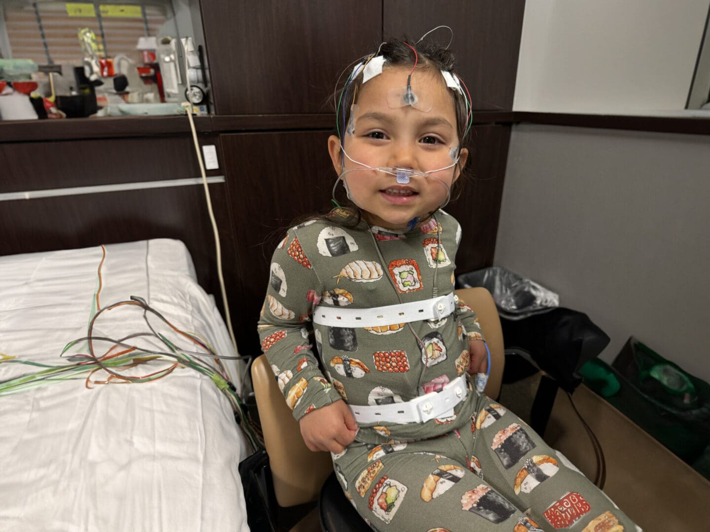 A young child with wires in his ears and nose.