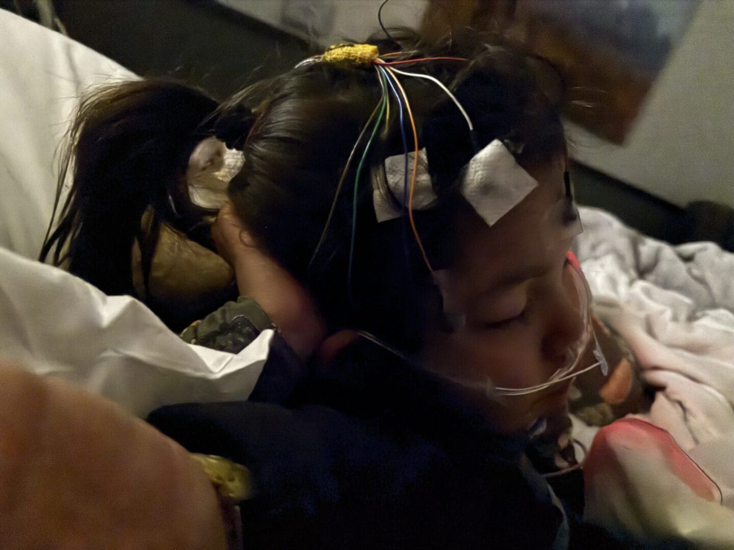 A girl with wires attached to her head.