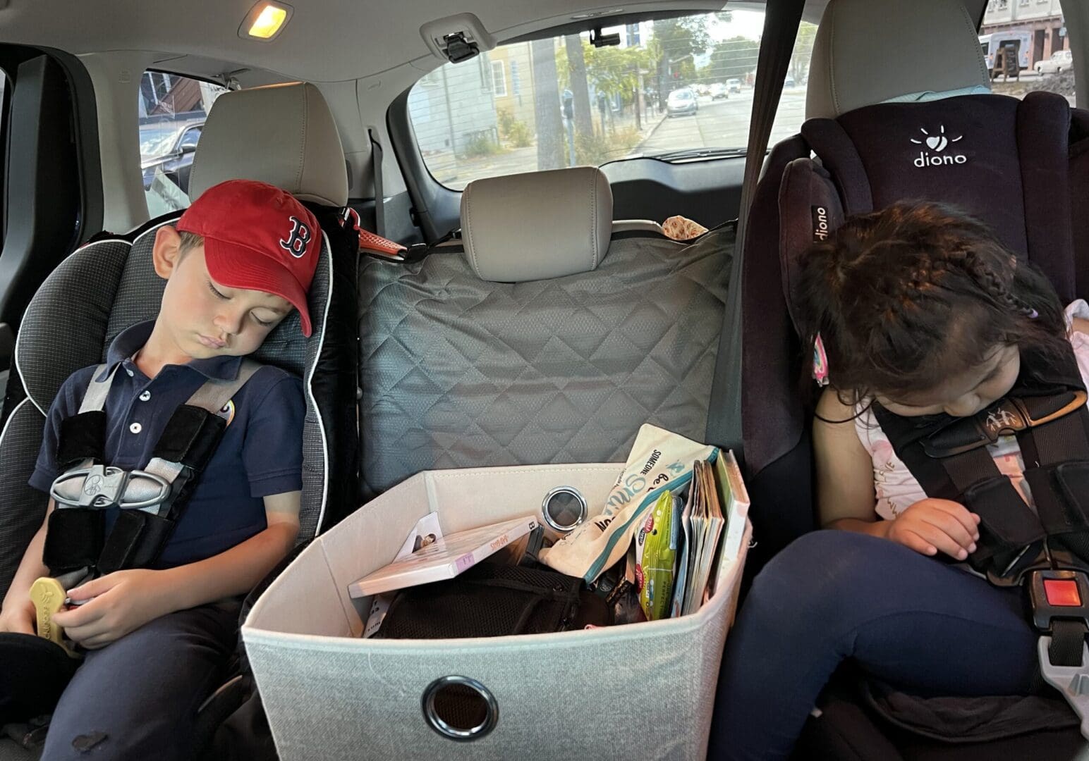 Two children sleeping in car seats.