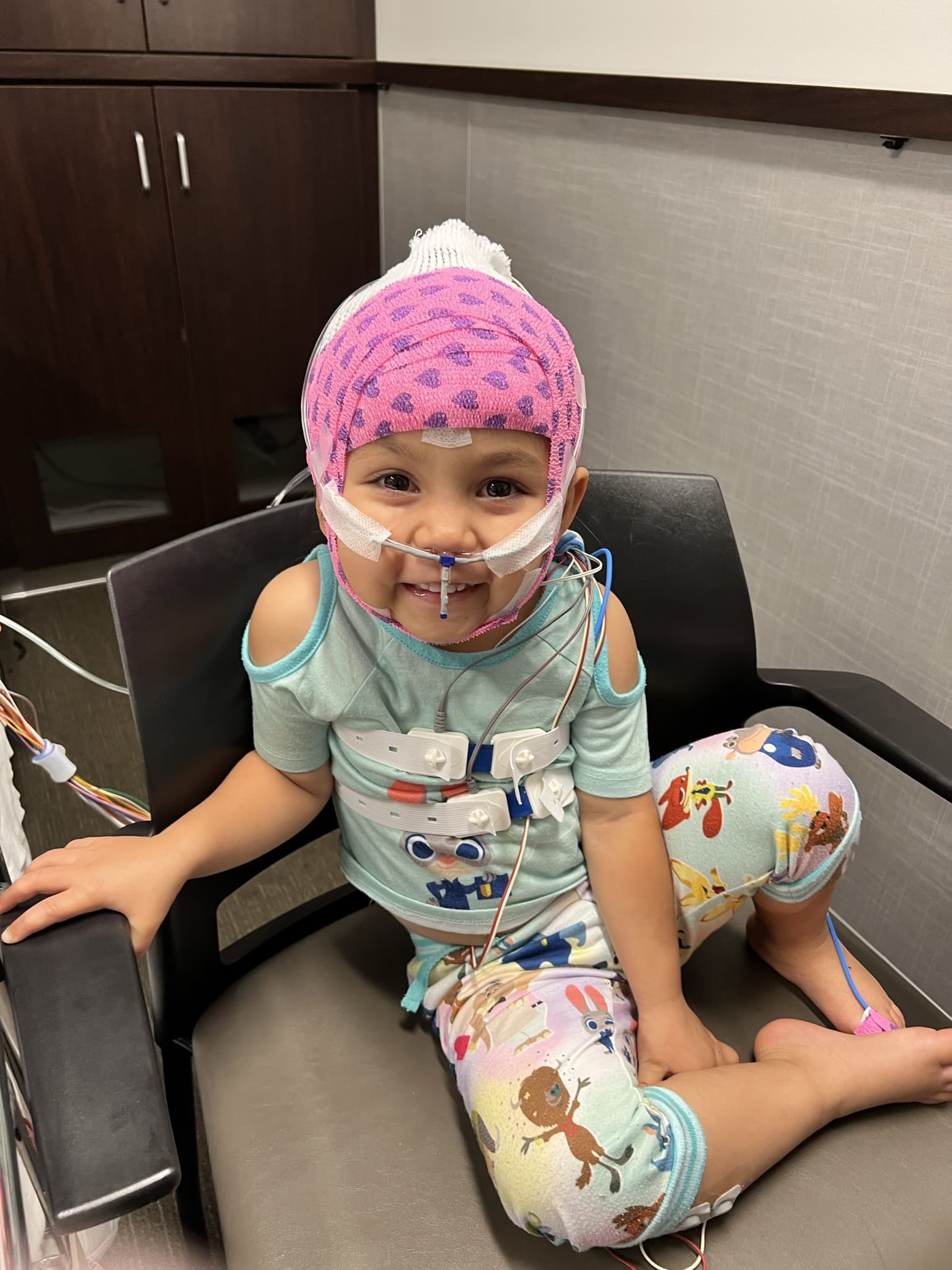 Smiling girl in sleep study headgear.