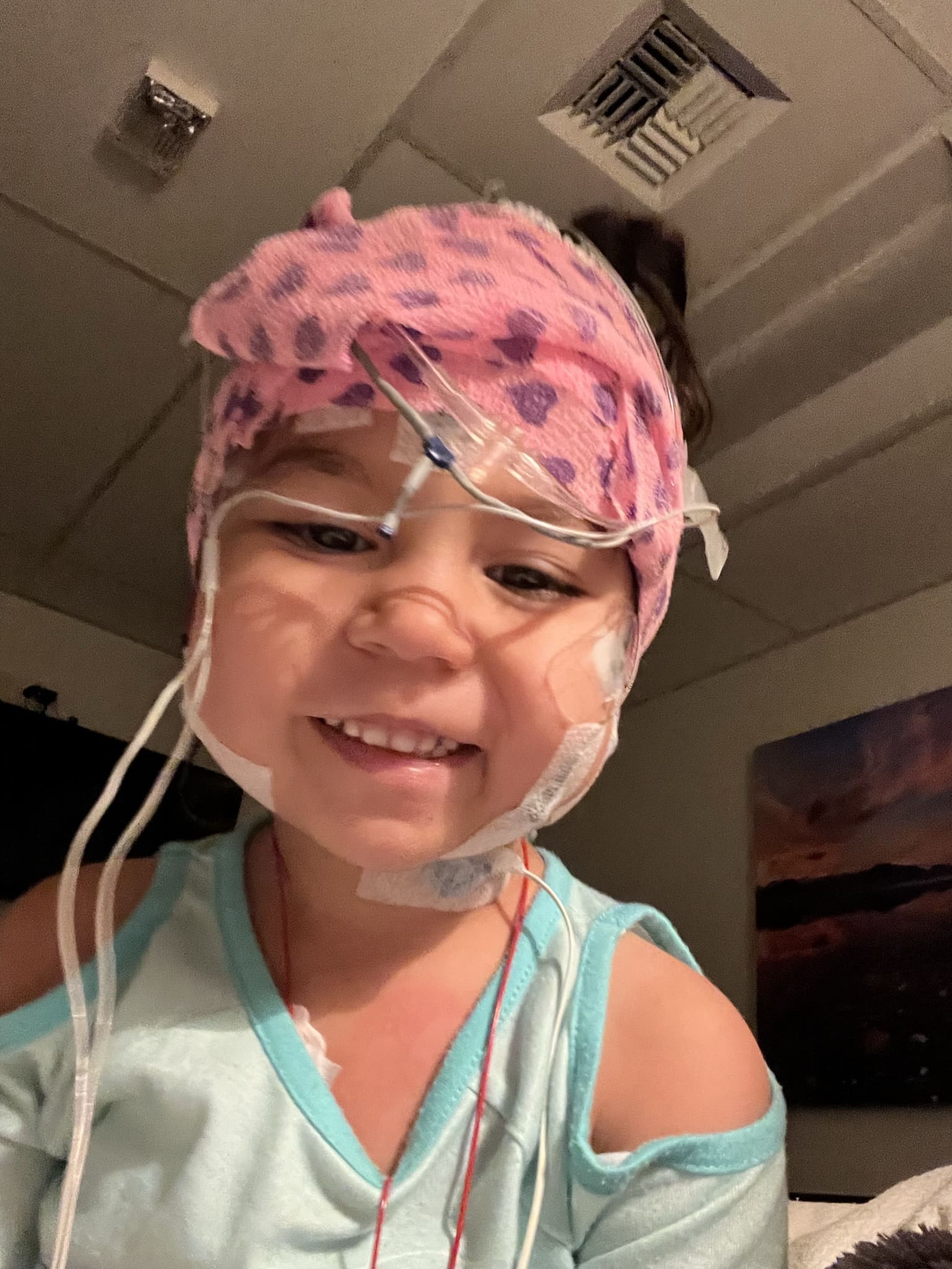 Smiling girl in sleep study cap.