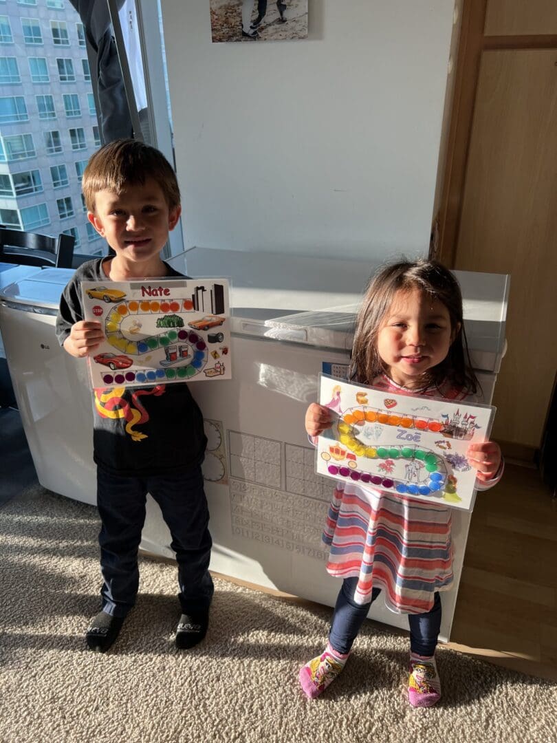 Kids proudly display their handmade board games.