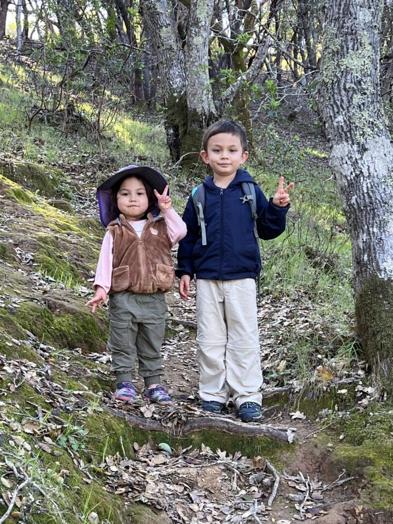 Two kids hiking in the woods.