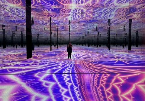 Woman in purple light art installation.